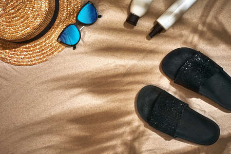 Summer background with straw hat, sunglasses, sunscreen bottle and flip flopsの写真素材