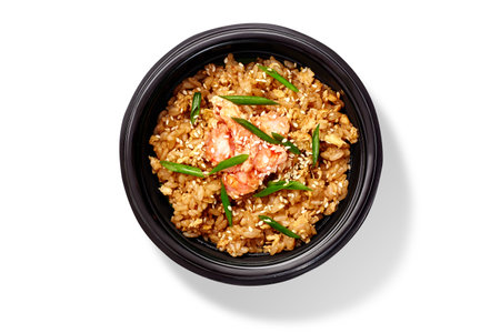Seafood chahan stir fried rice with shrimps, sesame and greens in black chawan isolated on whiteの写真素材