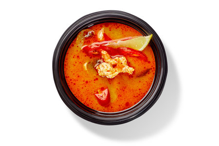 Bowl of Thai soup tom yam with chicken, red chili pepper and lemonの写真素材