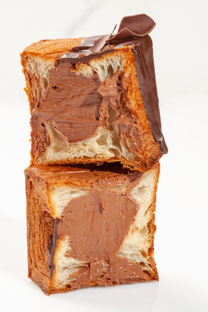 Sliced cubic croissant with chocolate custard filling, glaze and dark chocolate chipsの写真素材
