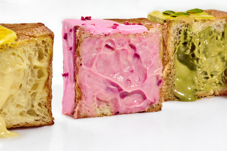 Sliced cube shaped croissants with sweet berry cream, vanilla and pistachio custardsの写真素材