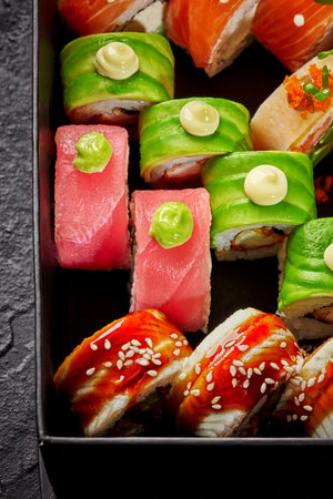 Set of various uramaki with salmon, tuna, eel and avocado in cardboard boxの写真素材