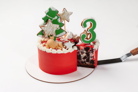 Sliced chocolate cake with figurine and shaped gingerbreadの写真素材