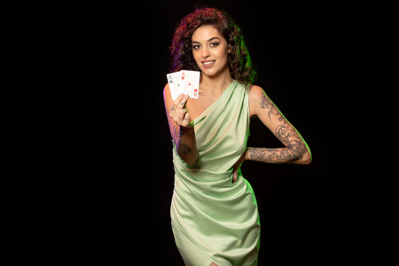 Smiling gambling young woman holding winning set of two acesの写真素材