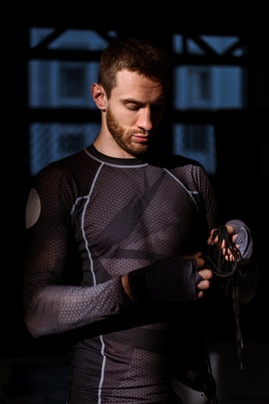 Bearded boxer readying for workout in rays of sunlight in gym