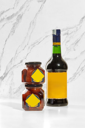 Baba preserving jars and borsci elixir bottle displayed on white marble surfaceの写真素材