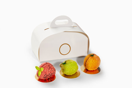 Pastry chef creating fruit shaped desserts with take away boxの写真素材