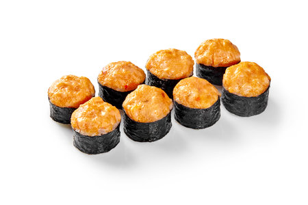 Baked sushi rolls with spicy sauce topping arranged on white backgroundの写真素材