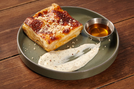 Delicious lasagna bolognese with white sauce on wooden table