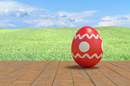 easter egg on planks against the field of grassの写真素材