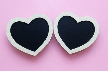 Blank heart shaped black board on a pink backgroundの写真素材