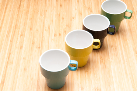 colourful mugs arranged on the breakfast tableの写真素材