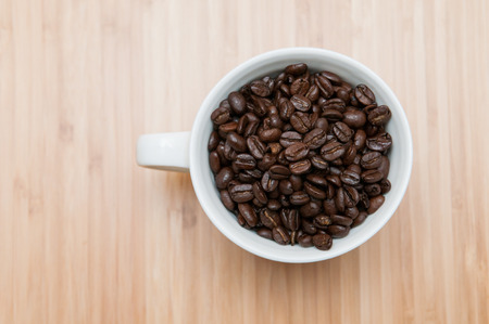 Strong flavoured coffee beans in a plain white mugの写真素材