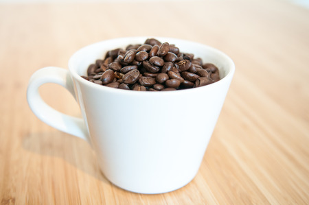 Strong flavoured coffee beans in a plain white mugの写真素材