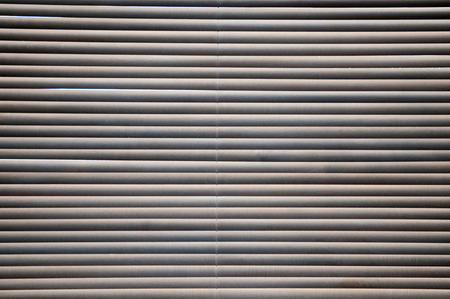 Morning sun shing through closed wooden blinds