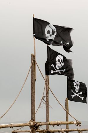 Skull and cross bones flag flying on a mastの写真素材