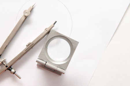 Linen counter being used to check work on a technical drawing