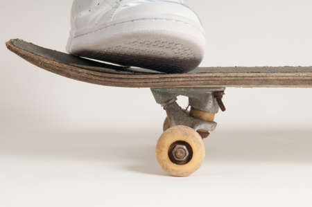 Man in clean white trainers doing tricks on an old skateboardの写真素材