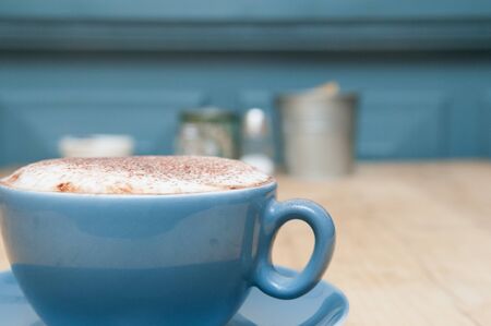 Freshly made cappuccino at a close up angle with copy space and blue themeの写真素材