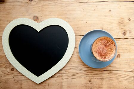 Cappucinno on a wooden cafe table viewed from aboveの写真素材