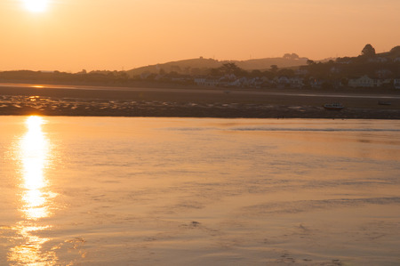 Sun rising over the water over the estuary leading to the oceanの写真素材