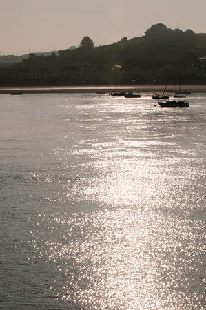 Sun rising over the water over the estuary leading to the oceanの写真素材