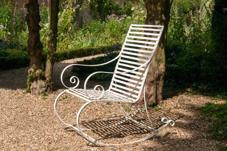 Garden furniture. Bench in a seating area of a formal gardenの写真素材