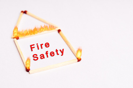 fire safety background concept with matches on fire in the shape of a homeの写真素材