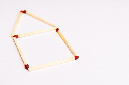 fire safety background concept with matches in the shape of a homeの写真素材