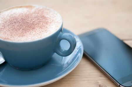 Cafe with connection with coffee and mobile phone on the tableの写真素材