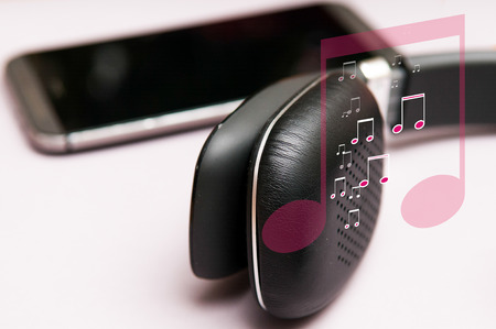 Listening to music on headphones with musical notes symbol graphicの写真素材