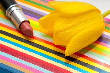 lipstick cosmetic product on a bright colorful striped backgroundの写真素材