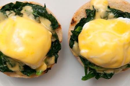 Eggs benedict or eggs florentine on a white plateの写真素材