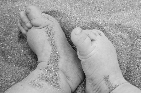 baby feet in the sand on a holidayの写真素材