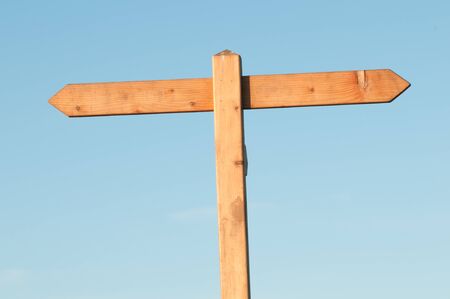 Wooden sign post on blue sky with space for textの写真素材