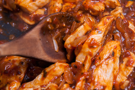 Chicken in toamto sauce cooking in a panの写真素材