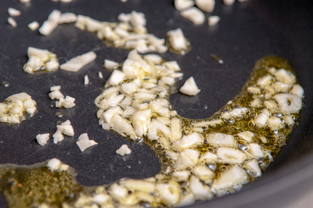 Chopped garlic cooking in hot olive oilの写真素材