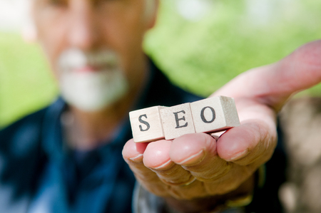 Male hand holding SEO lettering for website optimization and increase trafficの写真素材