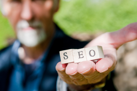 Male hand holding SEO lettering for website optimization and increase trafficの写真素材
