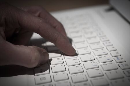 Internet crime, hand typing on a computer keyboard