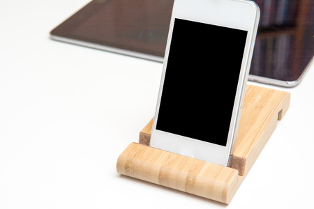 smart phone and tablet wireless charging on a white deskの写真素材