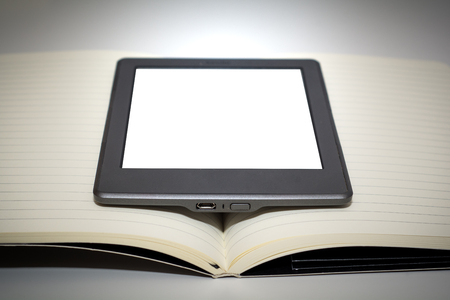 e reader device in the middle of the pages of a blank bookの写真素材