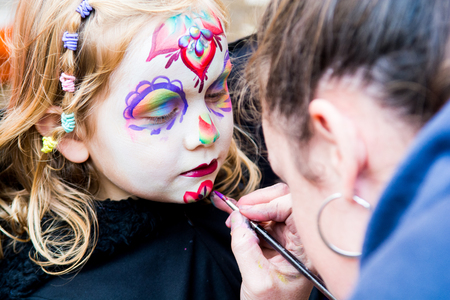 Young girl getting face painted by a make up artistの写真素材