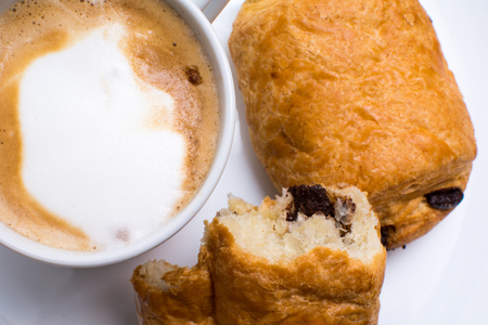 breakfast food on a plate, cappuccino coffee and chocolate croissantの写真素材