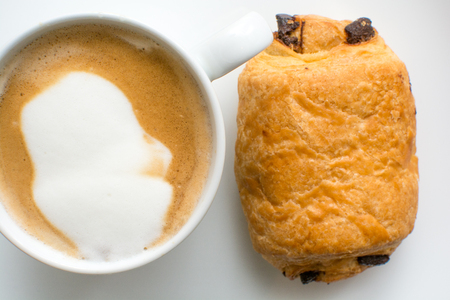 breakfast food on a plate, cappuccino coffee and chocolate croissantの写真素材