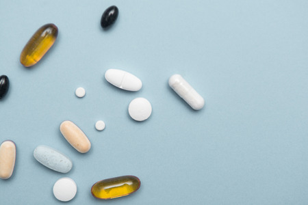 Prescription drugs isolated on a blue background, assorted tabletsの写真素材