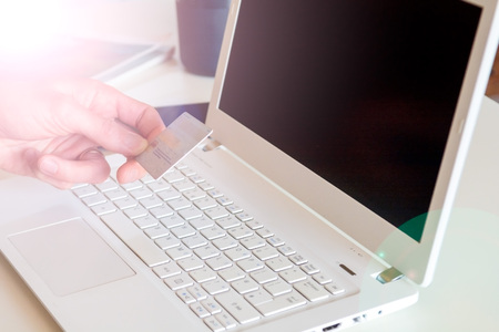 Hand holding credit card, online shopping on laptop computerの写真素材