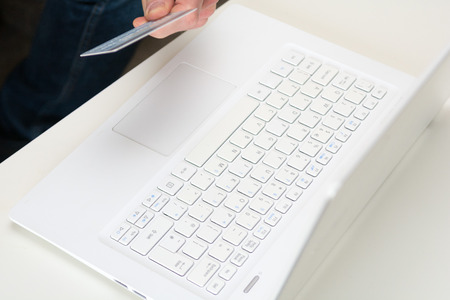 Hand holding credit card, online shopping on laptop computerの写真素材