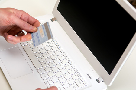 Hand holding credit card, online shopping on laptop computerの写真素材