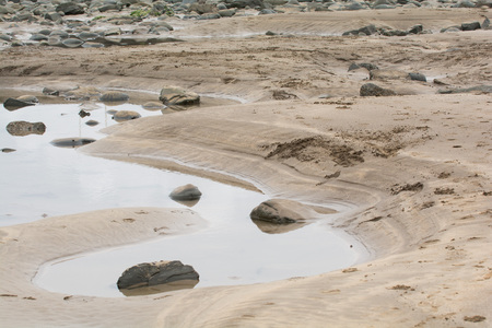 Sandy UK beach at low tide with rock poolsの写真素材
